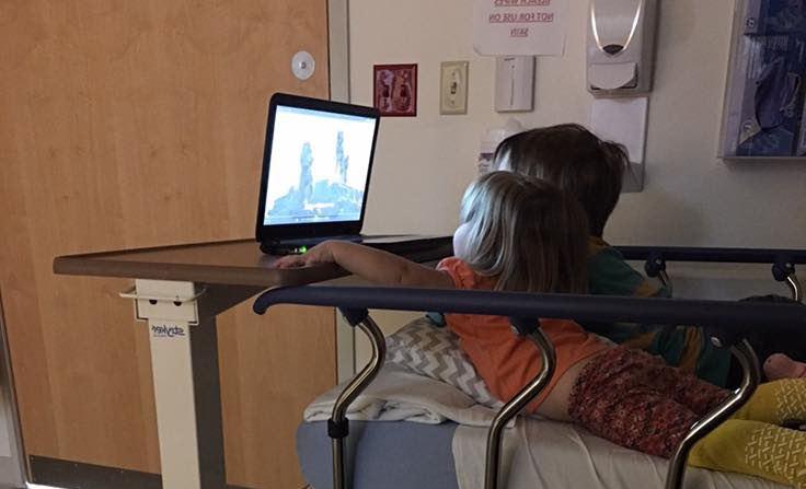 children watching tv on hospital bed
